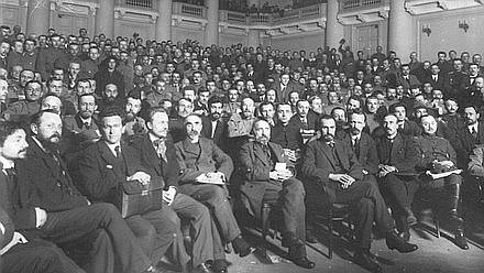 Delegados del Primer Congreso Panruso de los Soviets de Diputados Obreros y Soldados en el vestíbulo del Palacio de Táuride. Entre los delegados, están Nikolai Semenovich Chjeidze (6 a la izquierda), Georgy Valentinovich Plejanov (5 a la izquierda). Del 4 al 28 de mayo de 1917. La fotografía se almacena en el Archivo Estatal Central de Documentos Fílmicos y Fotográficos de San Petersburgo